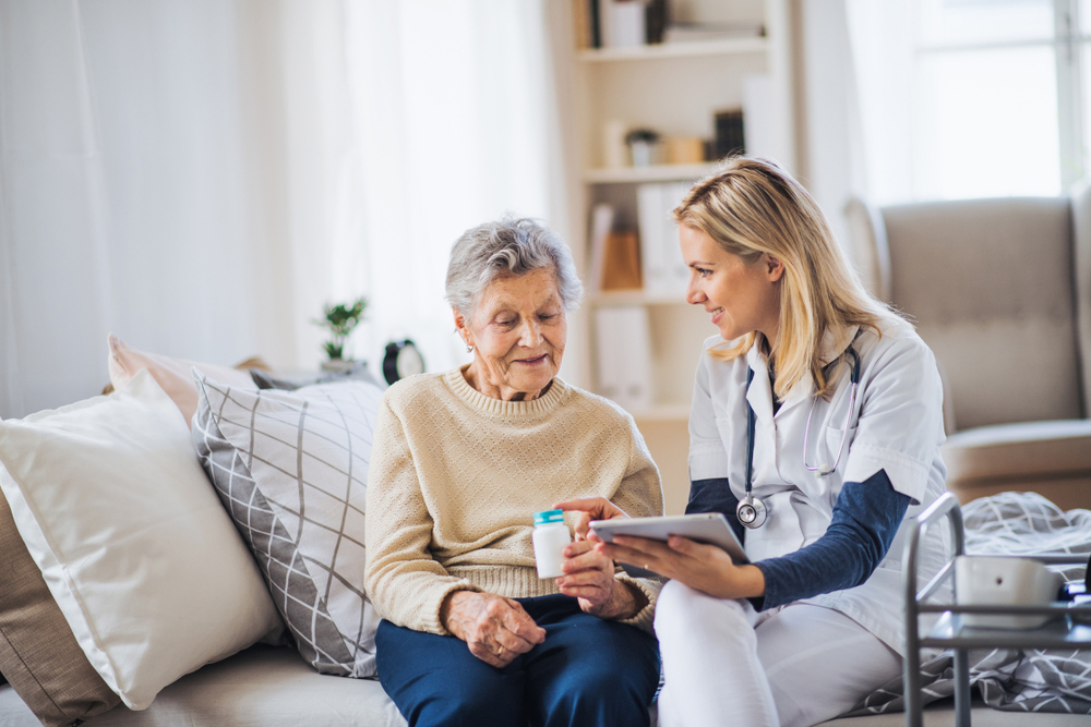 Nurse explaining medication to a patient in her home